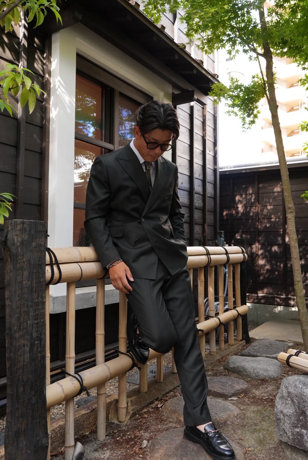 和風の店舗前に立つスーツ姿の男性